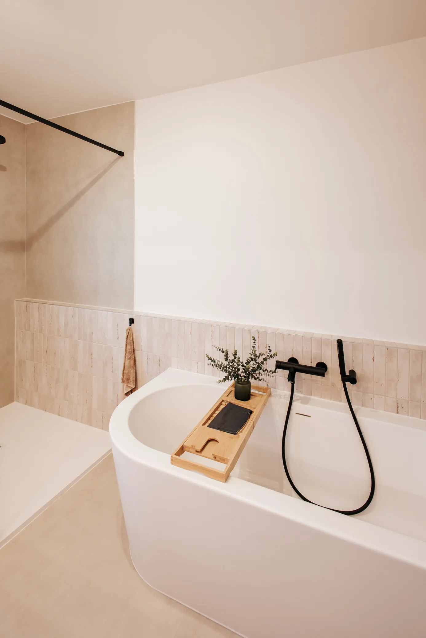 Badkamer met vrijstaand bad en beige zellige