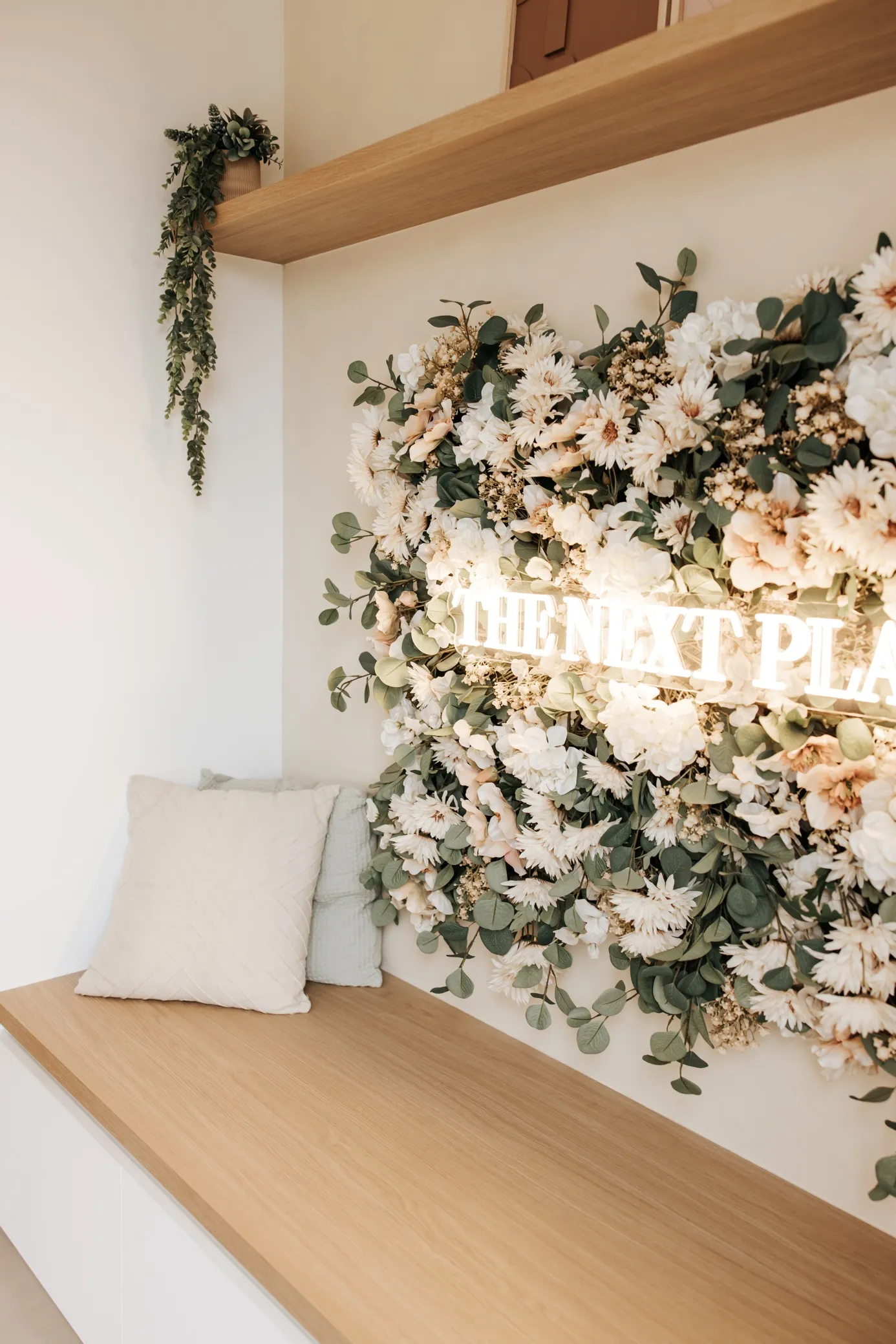Ontvangstruimte met bloemenwand en The Next Plan-signage