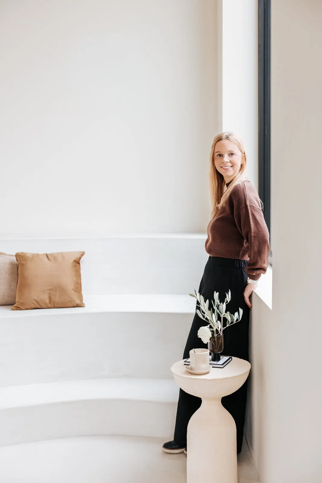 Freya Peetermans bij het raam in een licht interieur